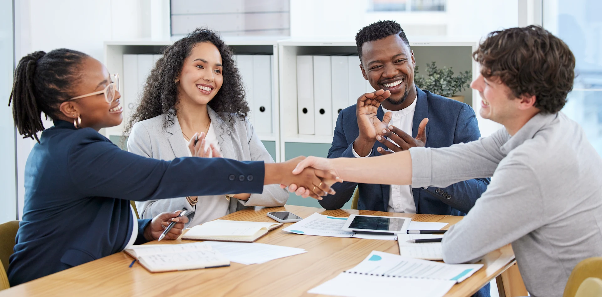 diverse professionals in office, hand-shake, celebration